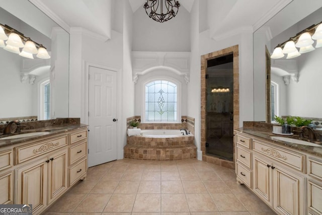full bath with a stall shower, a bath, two vanities, tile patterned floors, and high vaulted ceiling