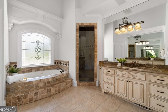 bathroom with tile patterned flooring, a stall shower, a garden tub, vanity, and a chandelier