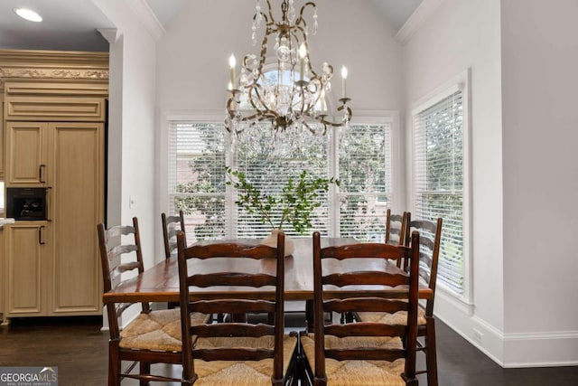 dining area featuring dark wood-type flooring, lofted ceiling, a chandelier, baseboards, and crown molding