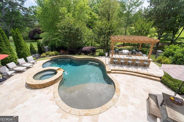 view of swimming pool with a patio area, a pool with connected hot tub, a pergola, and view of wooded area