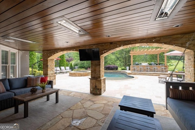 view of patio with an outdoor living space, an outdoor pool, an in-ground hot tub, an outdoor bar, and a ceiling fan