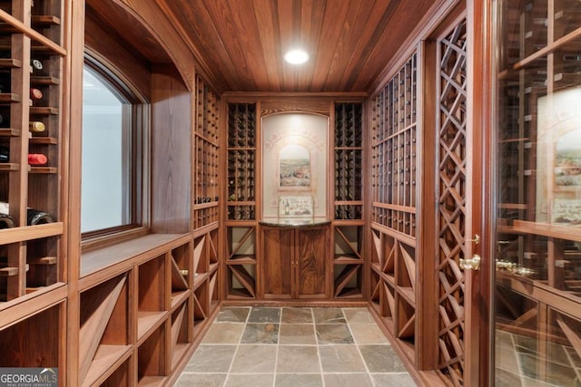 wine area with wooden ceiling, stone finish flooring, and recessed lighting