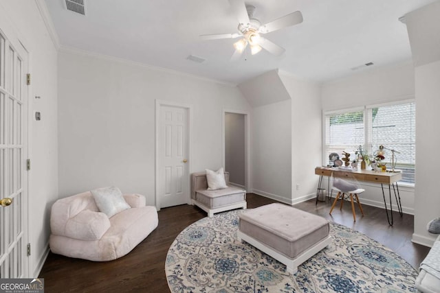 living area featuring dark wood-type flooring, ceiling fan, baseboards, and crown molding