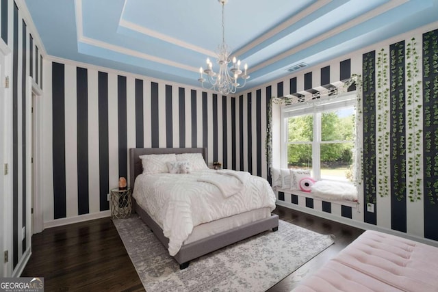 bedroom with a tray ceiling, a chandelier, wood finished floors, ornamental molding, and baseboards