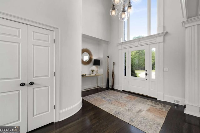 entrance foyer featuring a high ceiling, dark wood-style floors, baseboards, and a chandelier