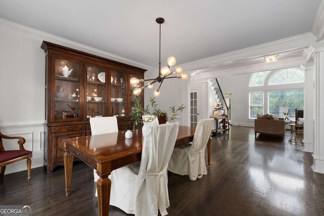 dining space with stairway, crown molding, a chandelier, dark wood-style floors, and wainscoting