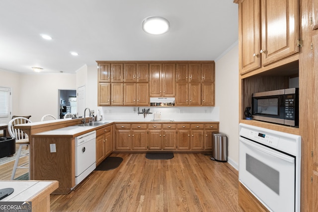 604 Clearwater Ct, Mcdonough, GA 30252 - kitchen with white appliances, a peninsula, light wood-style flooring, light countertops, and ornamental molding
