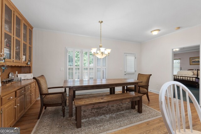 604 Clearwater Ct, Mcdonough, GA 30252 - dining room with crown molding, light wood-style flooring, and a chandelier