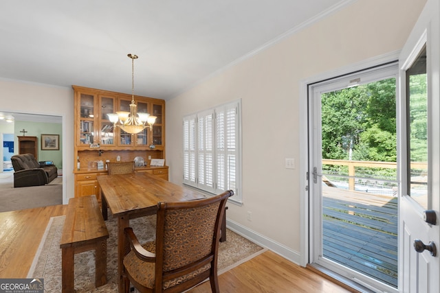 604 Clearwater Ct, Mcdonough, GA 30252 - dining area featuring a chandelier, light wood-type flooring, and crown molding