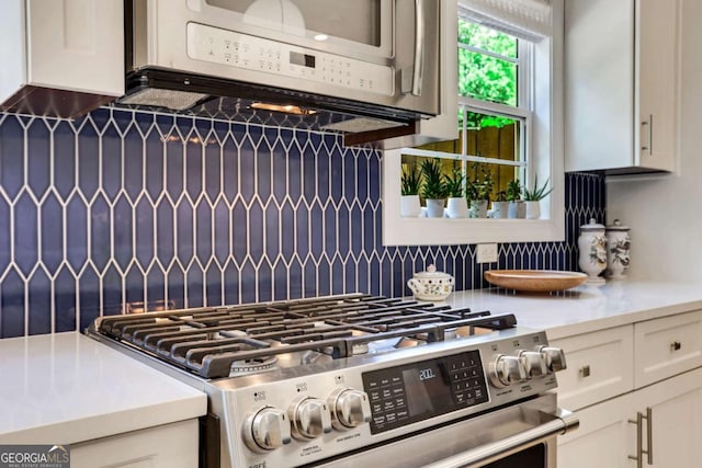 47 Roseclair Dr SE, Atlanta, GA 30317 - kitchen featuring stainless steel gas range oven, decorative backsplash, light countertops, and white cabinets