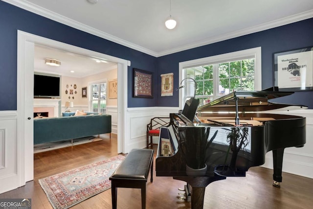 47 Roseclair Dr SE, Atlanta, GA 30317 - living area featuring wood finished floors, crown molding, a wainscoted wall, and a fireplace