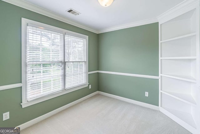 spare room featuring carpet, ornamental molding, and baseboards