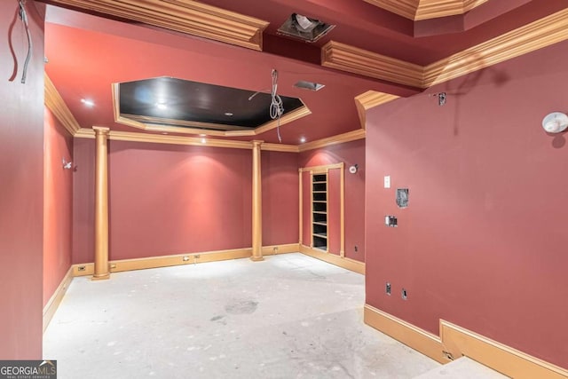 home theater room featuring decorative columns, ornamental molding, a raised ceiling, and baseboards