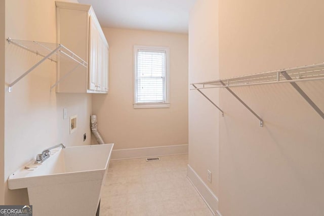 clothes washing area with cabinet space, baseboards, electric dryer hookup, and washer hookup