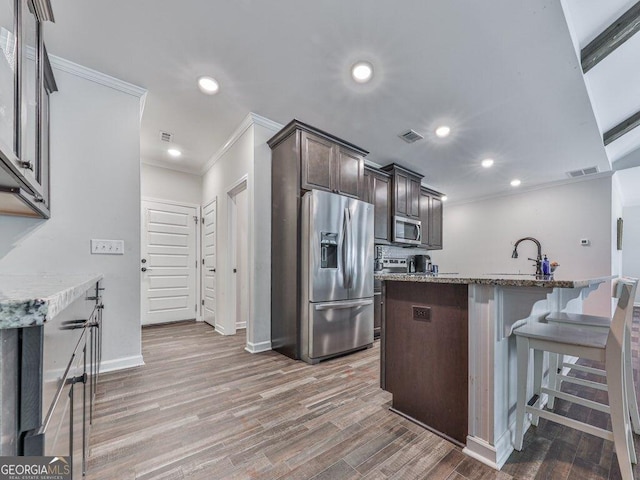 308 Feather Perch, Waleska, GA 30183 - kitchen featuring stainless steel appliances, crown molding, a sink, dark brown cabinetry, and light stone counters