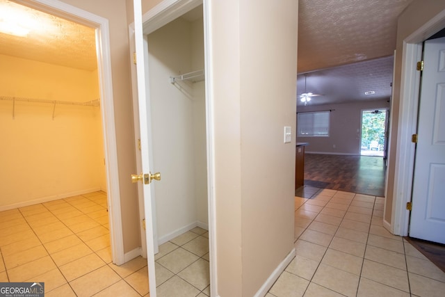 4015 Hidden Hollow Dr, Gainesville, GA 30506 - hallway featuring light tile patterned floors, a textured ceiling, and baseboards
