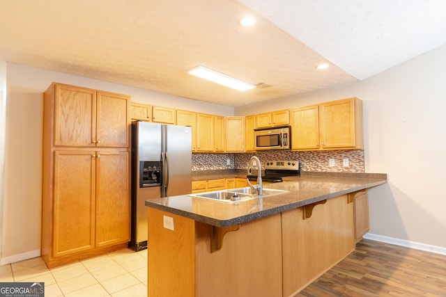 4015 Hidden Hollow Dr, Gainesville, GA 30506 - kitchen featuring stainless steel appliances, baseboards, a sink, a peninsula, and a kitchen breakfast bar