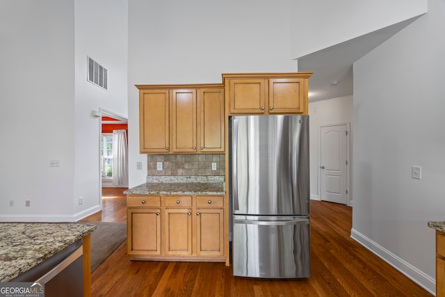 924 Vinings Dr, Winder, GA 30680 - kitchen with freestanding refrigerator, a high ceiling, dark wood finished floors, baseboards, and light stone countertops