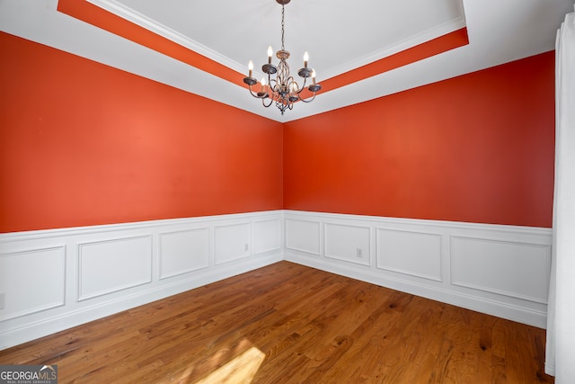 924 Vinings Dr, Winder, GA 30680 - spare room with a chandelier, wainscoting, crown molding, wood finished floors, and a raised ceiling