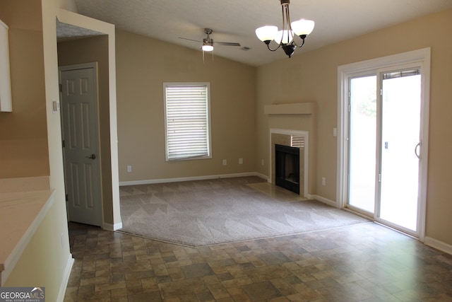 unfurnished living room featuring a ceiling fan, carpet, baseboards, stone finish floors, and lofted ceiling