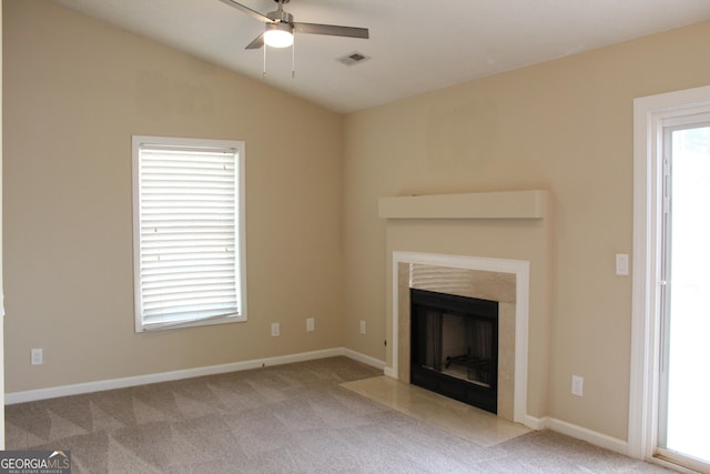 unfurnished living room featuring a ceiling fan, a fireplace with flush hearth, carpet flooring, lofted ceiling, and baseboards