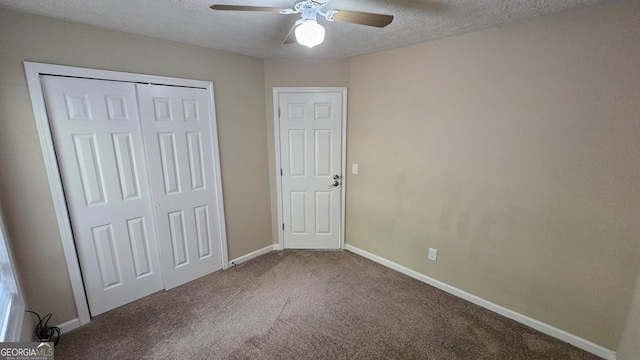 unfurnished bedroom featuring carpet flooring, a textured ceiling, a closet, baseboards, and ceiling fan