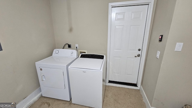 laundry room with separate washer and dryer and baseboards