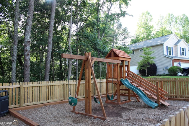 view of play area with fence and view of wooded area