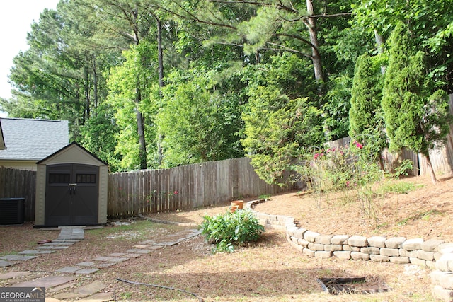 fenced backyard featuring cooling unit, a storage unit, and an outbuilding