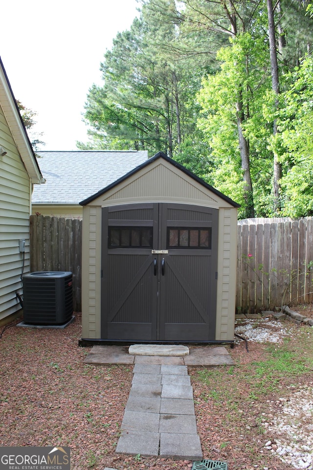 view of shed featuring fence and central AC