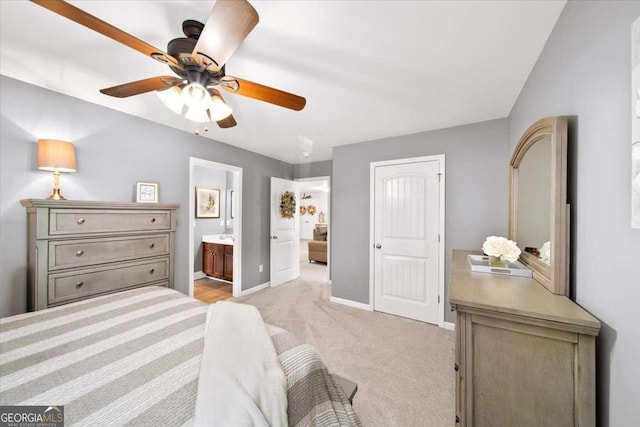 bedroom featuring baseboards, light carpet, ensuite bath, and a ceiling fan