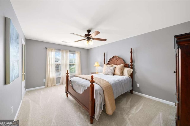 bedroom featuring light carpet, baseboards, and a ceiling fan