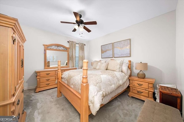 bedroom featuring light carpet, a ceiling fan, and baseboards