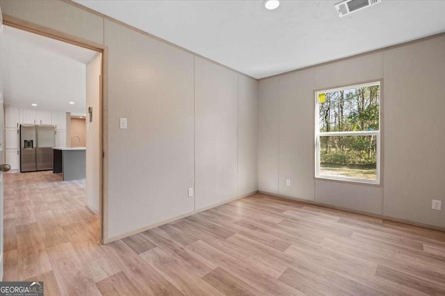 unfurnished room with light wood-type flooring, recessed lighting, and a sink
