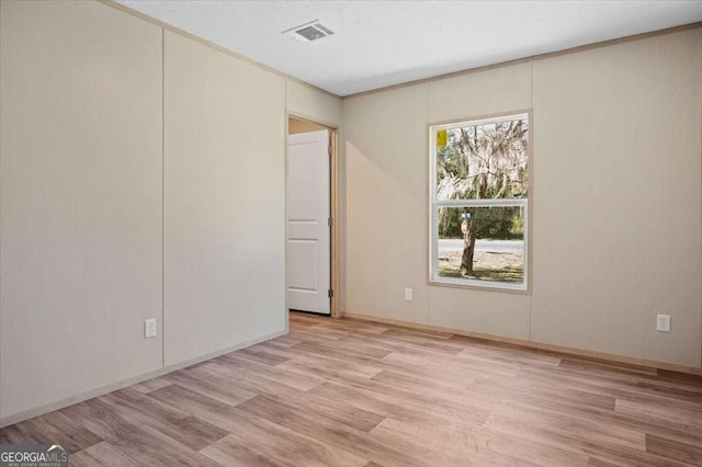 empty room with light wood finished floors and baseboards