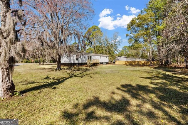view of grassy yard featuring a deck