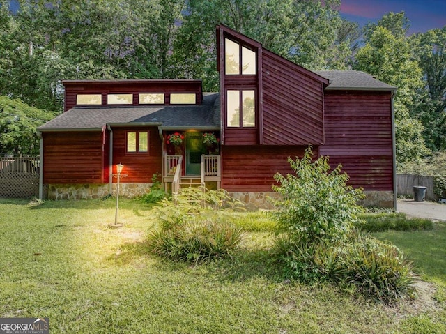 mid-century home featuring roof with shingles