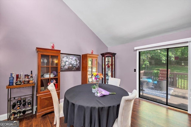 dining space with dark wood-style flooring, high vaulted ceiling, and baseboards