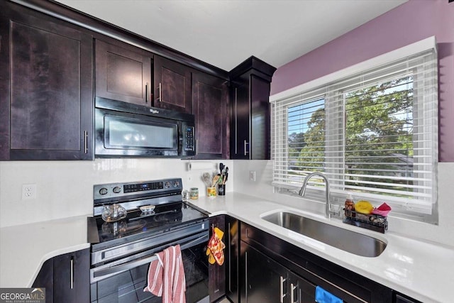 kitchen featuring electric stove, black microwave, a sink, light countertops, and dark brown cabinetry