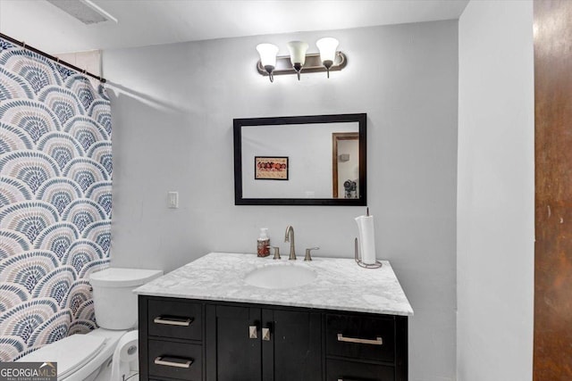 full bath featuring toilet, vanity, and curtained shower
