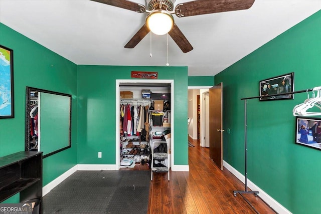 bedroom featuring hardwood / wood-style flooring, baseboards, ceiling fan, and a closet
