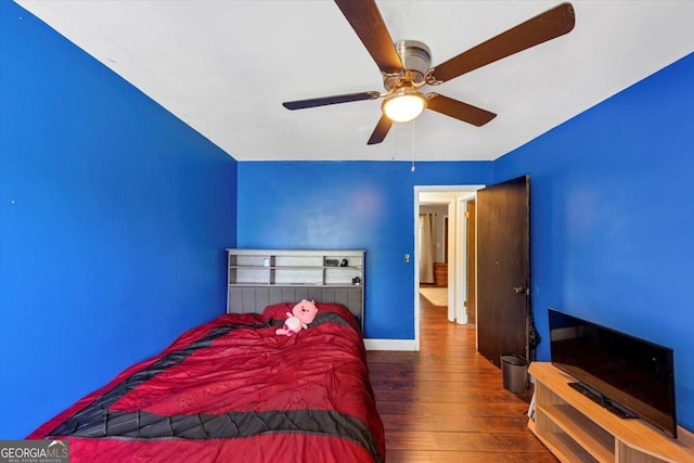 bedroom featuring wood finished floors, baseboards, and ceiling fan