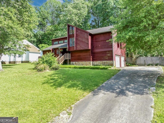 view of front of house with driveway, a garage, and stone siding