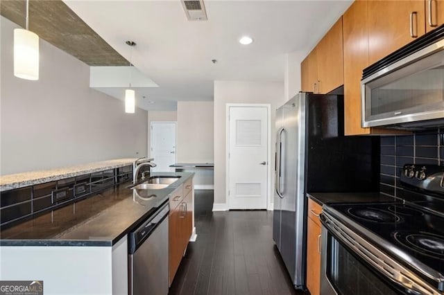 950 W Peachtree St NW Unit 1613, Atlanta, GA 30309 - kitchen featuring stainless steel appliances, a sink, brown cabinets, tasteful backsplash, and dark wood-style flooring