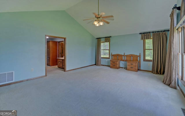 unfurnished bedroom with high vaulted ceiling, baseboards, light colored carpet, a ceiling fan, and ensuite bath