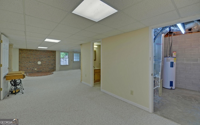 below grade area featuring water heater, a drop ceiling, carpet, and baseboards