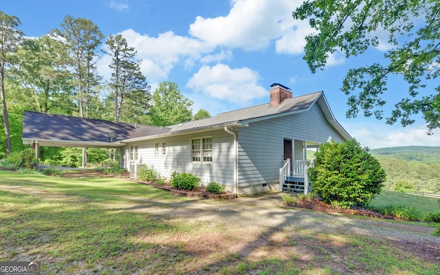 rear view of property with a chimney and a lawn