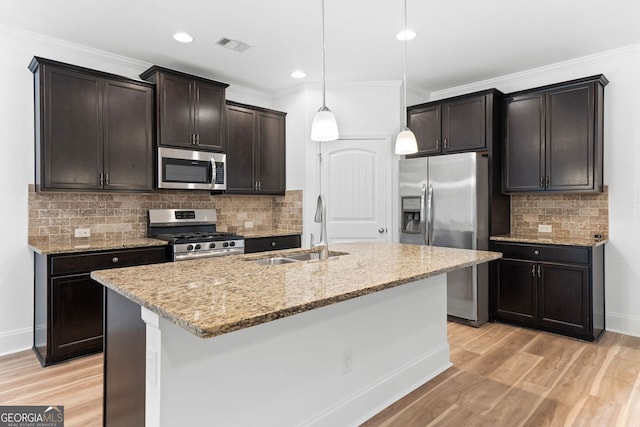 3805 Alden Pl, Cumming, GA 30028 - kitchen featuring appliances with stainless steel finishes, decorative backsplash, light stone countertops, light wood-style flooring, and ornamental molding
