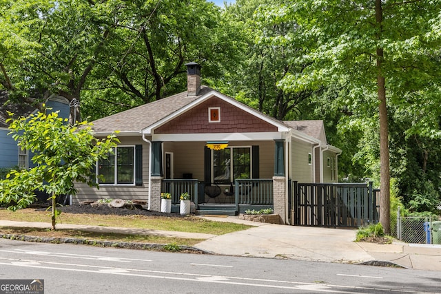 770 Ormewood Ave SE, Atlanta, GA 30312 - view of front of house with covered porch, a chimney, roof with shingles, and driveway
