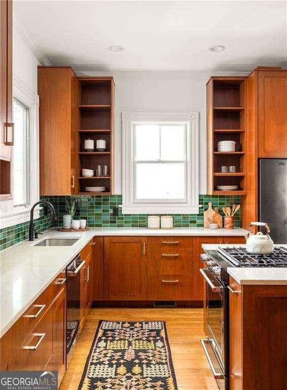 629 Hansell St SE, Atlanta, GA 30312 - kitchen featuring open shelves, appliances with stainless steel finishes, a sink, and brown cabinets